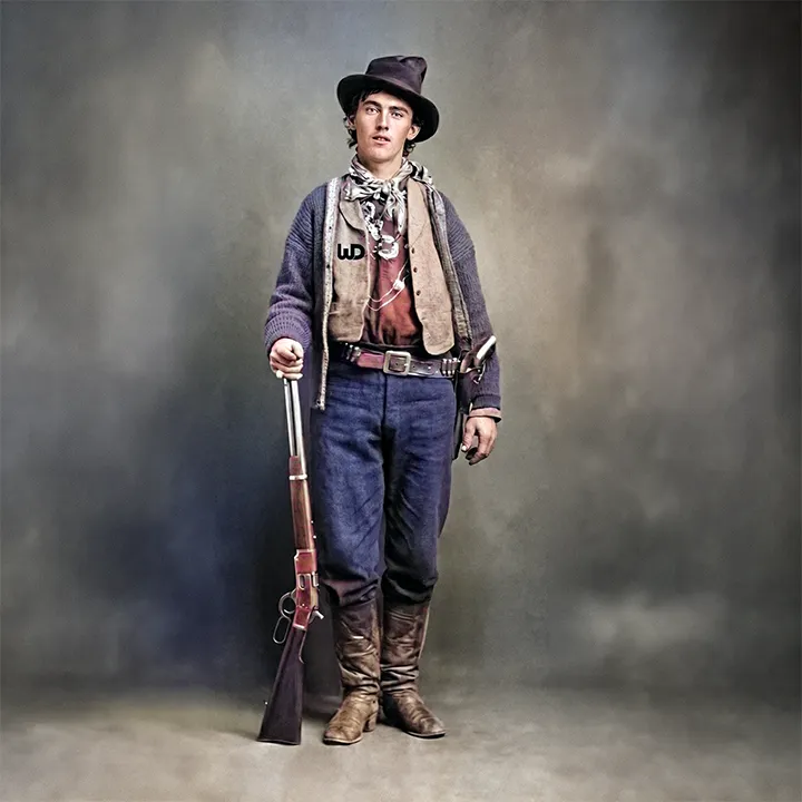 Colorized 19th-century vintage portrait of William H. Bonney (Billy the Kid) wearing a vest with a subtle Womp Designs logo.
